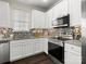 Modern kitchen featuring white cabinets, stainless steel appliances, and stylish backsplash at 8037 Lynwood Sq, Waxhaw, NC 28173
