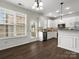 A well-lit kitchen showcasing white cabinets, dark wood floors, and stainless steel appliances at 8037 Lynwood Sq, Waxhaw, NC 28173