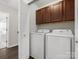 The laundry room has a washer, dryer, and upper cabinets at 8037 Lynwood Sq, Waxhaw, NC 28173