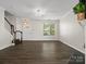 Open-concept living room with dark wood floors, staircase, and abundant natural light at 8037 Lynwood Sq, Waxhaw, NC 28173