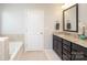 Bright bathroom features a soaking tub, modern vanity with granite countertop, and tiled floors at 8317 Dallas Bay Rd, Charlotte, NC 28278