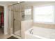 Bright bathroom with glass shower, soaking tub, tiled floors and niche for toiletries at 8317 Dallas Bay Rd, Charlotte, NC 28278