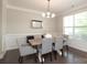 Elegant dining room featuring a modern chandelier, wainscoting, and ample natural light at 8317 Dallas Bay Rd, Charlotte, NC 28278