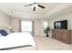 Spacious main bedroom with a tray ceiling, ceiling fan, large bed, dresser, and natural light at 8317 Dallas Bay Rd, Charlotte, NC 28278