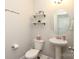 Clean powder room with pedestal sink, decorative shelving, and modern fixtures at 8317 Dallas Bay Rd, Charlotte, NC 28278
