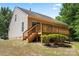 View of the home's rear exterior, showcasing a wooden deck and a serene backyard with lush greenery at 8347 Fox Swamp Rd, Charlotte, NC 28215