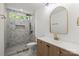 Modern bathroom showcasing a marble tiled shower with gold accents, a vanity, and an arched mirror at 8347 Fox Swamp Rd, Charlotte, NC 28215