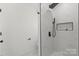 Modern shower with black hardware, a large rain shower head, and a white tiled wall at 8347 Fox Swamp Rd, Charlotte, NC 28215