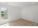 Sunlit bedroom with hardwood floors, white walls, a large window, and recessed lighting at 8347 Fox Swamp Rd, Charlotte, NC 28215