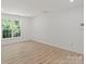Bright, white room with hardwood floors and a window overlooking foliage at 8347 Fox Swamp Rd, Charlotte, NC 28215
