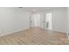 Bright, white room with hardwood floors and doors leading to a room with a bathroom at 8347 Fox Swamp Rd, Charlotte, NC 28215