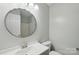 Bright bathroom features a round mirror over a vanity with modern fixtures and white walls at 908 Dairy Meadow Ct, Monroe, NC 28110