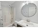 Bright bathroom featuring a shower and tub, round mirror, updated fixtures, and storage at 908 Dairy Meadow Ct, Monroe, NC 28110