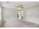 Spacious bedroom featuring a ceiling fan, plush carpet, and an ensuite entrance to the kitchen and bathroom at 908 Dairy Meadow Ct, Monroe, NC 28110