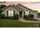 Charming single-story home featuring manicured landscaping and a welcoming front entrance at 908 Dairy Meadow Ct, Monroe, NC 28110
