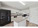 Bright kitchen features an island with granite countertops and black appliances at 908 Dairy Meadow Ct, Monroe, NC 28110