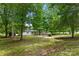 Serene backyard with lush trees surrounding a charming home at 925 Crestland Dr, Clover, SC 29710