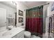 Bathroom features a single sink vanity, toilet and a shower with decorative curtain at 9359 Hillston Ridge Rd, Huntersville, NC 28078