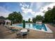 Large community pool with plenty of seating on a sunny day, surrounded by trees at 9359 Hillston Ridge Rd, Huntersville, NC 28078