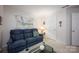 Living room features a blue sofa, a decorative hanging and glass coffee table at 9359 Hillston Ridge Rd, Huntersville, NC 28078