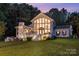 Beautiful two-story home with large windows, a welcoming porch, and manicured lawn at twilight at 108 Balmoral Dr, Mooresville, NC 28117