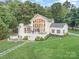 Stunning aerial view of a white two-story home with a large yard, trees, and an inviting outdoor living space at 108 Balmoral Dr, Mooresville, NC 28117