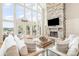 Bright and airy living room with a stone fireplace, soaring windows, and comfortable neutral furniture at 108 Balmoral Dr, Mooresville, NC 28117