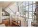 Open-concept living room with a fireplace, lake views from a wall of windows, and hardwood floors at 108 Balmoral Dr, Mooresville, NC 28117