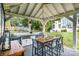 Outdoor kitchen featuring a grill, bar seating, and a dining table, perfect for entertaining guests at 108 Balmoral Dr, Mooresville, NC 28117