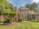 Manicured backyard with lush lawn and brick home exterior, offering a private and inviting outdoor space at 10924 Lederer Ave, Charlotte, NC 28277