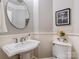 Powder room features pedestal sink, wainscotting, and neutral decor at 10924 Lederer Ave, Charlotte, NC 28277