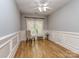 Light-filled bedroom with hardwood floors, elegant trim, and a cozy seating area by the window at 10924 Lederer Ave, Charlotte, NC 28277