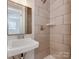 Bathroom featuring tiled walls, a modern sink and faucet with a mirror at 1147 Norland Rd, Charlotte, NC 28205