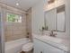 Updated bathroom featuring tiled walls, a bathtub, and a modern vanity with ample lighting at 1147 Norland Rd, Charlotte, NC 28205