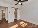 Bedroom with a ceiling fan, wood floors, and bathroom with a tiled shower and a glass shower door at 1147 Norland Rd, Charlotte, NC 28205