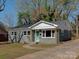Charming gray brick home with a well-manicured lawn and a welcoming light-green front door at 1147 Norland Rd, Charlotte, NC 28205