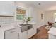 Bright kitchen featuring white cabinets, stainless steel sink, and hardwood floors at 1147 Norland Rd, Charlotte, NC 28205