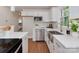 Well-lit kitchen featuring white subway tile backsplash, stainless appliances, and a farmhouse sink at 1147 Norland Rd, Charlotte, NC 28205
