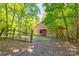 A large barn in a wooded perimeter with a fence in the front at 11861 Nc Hwy 73 E Hwy, Mount Pleasant, NC 28124