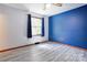 Bedroom featuring stylish gray laminate flooring and a modern blue accent wall at 11861 Nc Hwy 73 E Hwy, Mount Pleasant, NC 28124