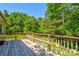This beautiful wooden backyard deck is spacious and overlooks a verdant lot filled with mature trees at 11861 Nc Hwy 73 E Hwy, Mount Pleasant, NC 28124