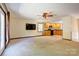 Open-concept living room with kitchen, ceiling fan, and glass doors leading to the backyard at 11861 Nc Hwy 73 E Hwy, Mount Pleasant, NC 28124