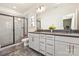 Bright bathroom with a dual vanity, tile flooring, modern fixtures, and a glass-enclosed shower at 13022 Simoneaux Ln, Charlotte, NC 28277