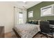 Comfortable bedroom featuring a patterned comforter, natural light, and a dedicated workspace at 13022 Simoneaux Ln, Charlotte, NC 28277