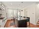 Bright kitchen featuring an island with marble countertop, modern cabinetry, stainless steel appliances, and hardwood floors at 13022 Simoneaux Ln, Charlotte, NC 28277