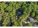 Stunning aerial view of a house nestled in a lush, green, wooded setting, with a pool and driveway at 131 Sierra Woods Dr, Troutman, NC 28166