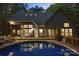 Beautiful backyard featuring a private pool, wooden deck with lounge seating, and a brick home exterior at 131 Sierra Woods Dr, Troutman, NC 28166