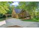 Brick home featuring a carport, garage, and well-maintained landscaping, all surrounded by mature trees at 131 Sierra Woods Dr, Troutman, NC 28166