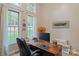 Bright office with large windows, desk, and chair, with view to the backyard at 131 Sierra Woods Dr, Troutman, NC 28166