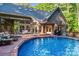 Backyard swimming pool with wooden deck, patio furniture, and lush green landscaping at 131 Sierra Woods Dr, Troutman, NC 28166